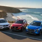 A wide shot of the Chery Tiggo 4, MG ZS, and GWM Haval Jolion lined up on an Australian coastal road