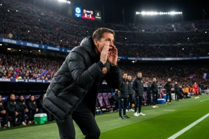 Hansi Flick shouting instructions from the Barcelona touchline during a night match at the Camp Nou
