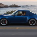 Side profile of the Singer Porsche 911 Carrera Cabriolet in Pacific Blue with the Z-fold roof stowed.